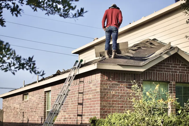 Professional roofer working on a residential roof in Sharpstown